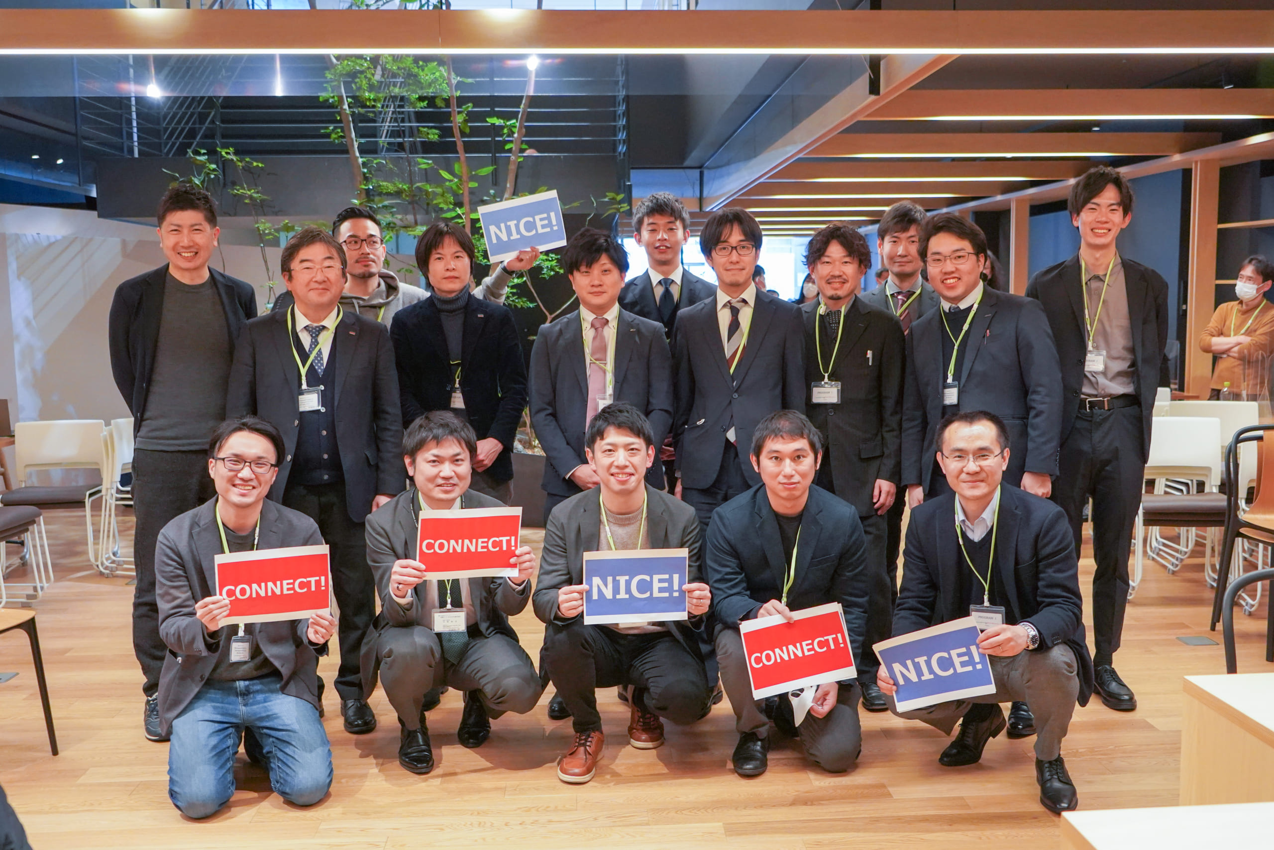 Group photo of KAP members. Each of the five people at the front is holding a placard saying 'connect' or 'nice'
