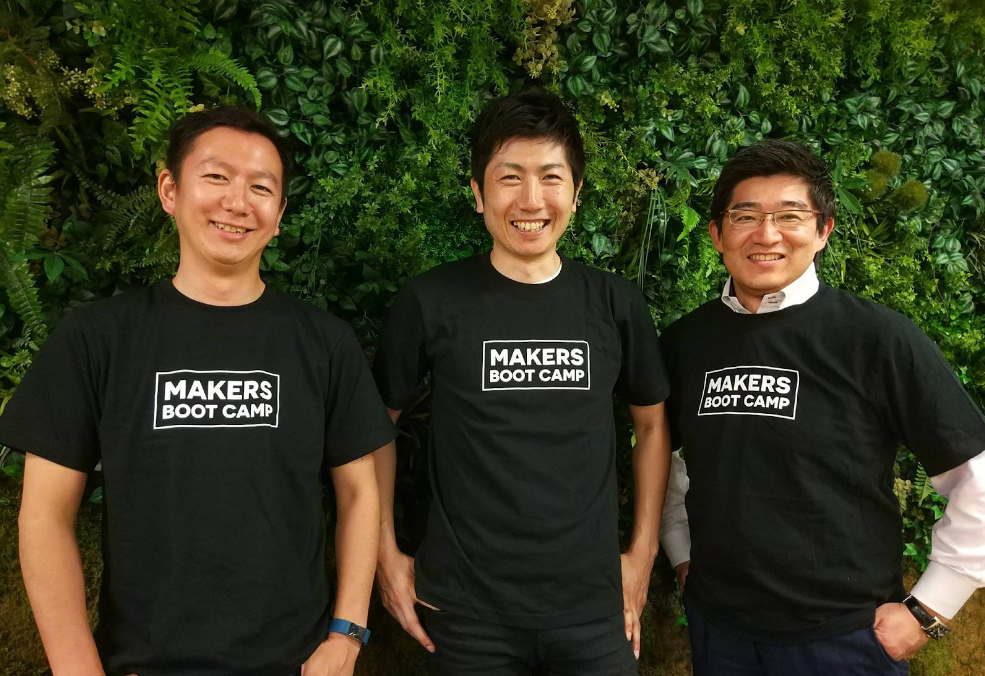 three people all weathering black T-shirts with a logo “Makers Boot Camp” on their chest. Founders of Darma Tech Labs in 2015. From left, Fujiwara (CEO of Hacarus), Makino, and Takeda(CEO of CrossEffect)